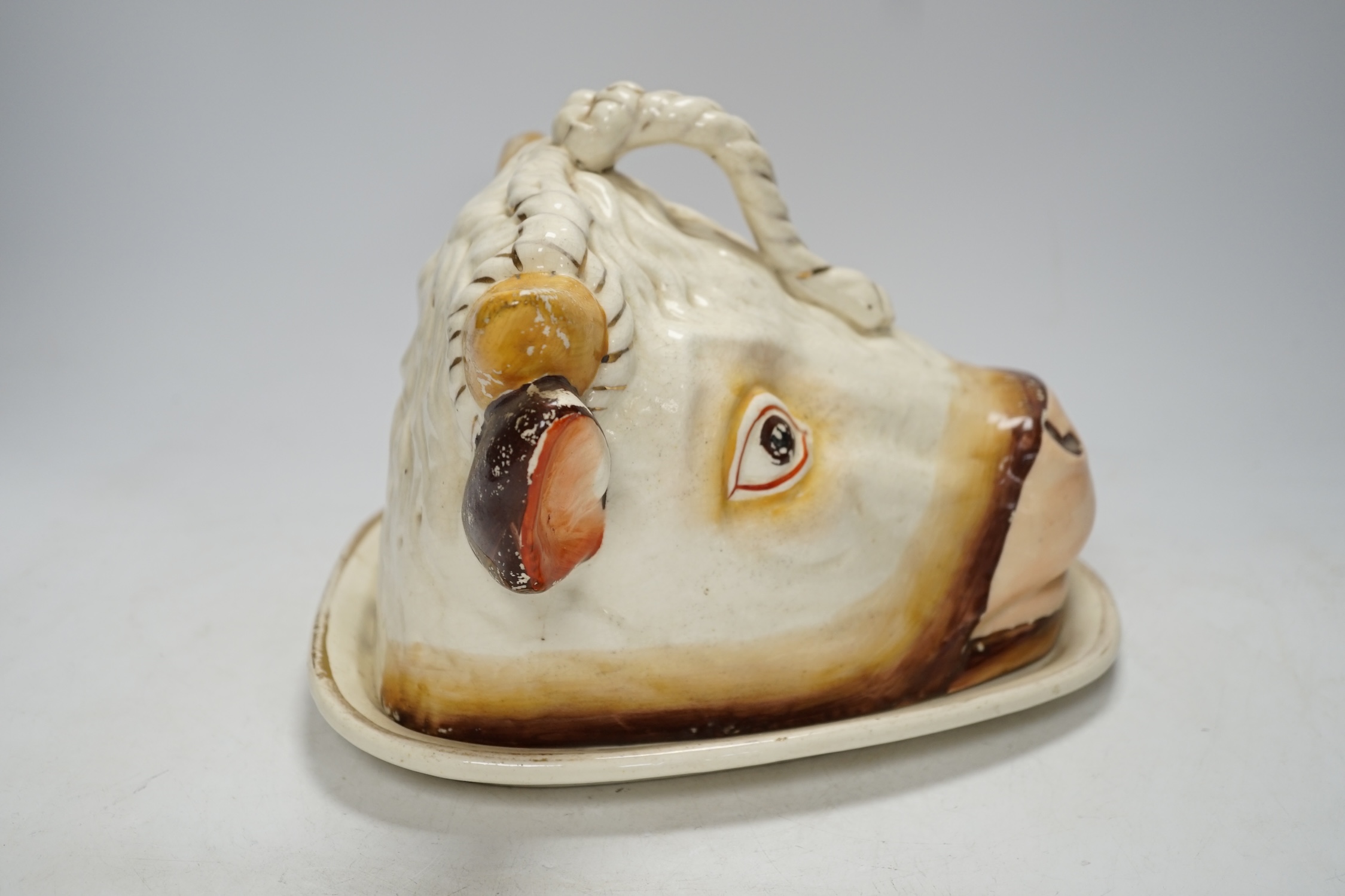 A Victorian ‘cows head’ pottery cheese dish and cover, 18cm